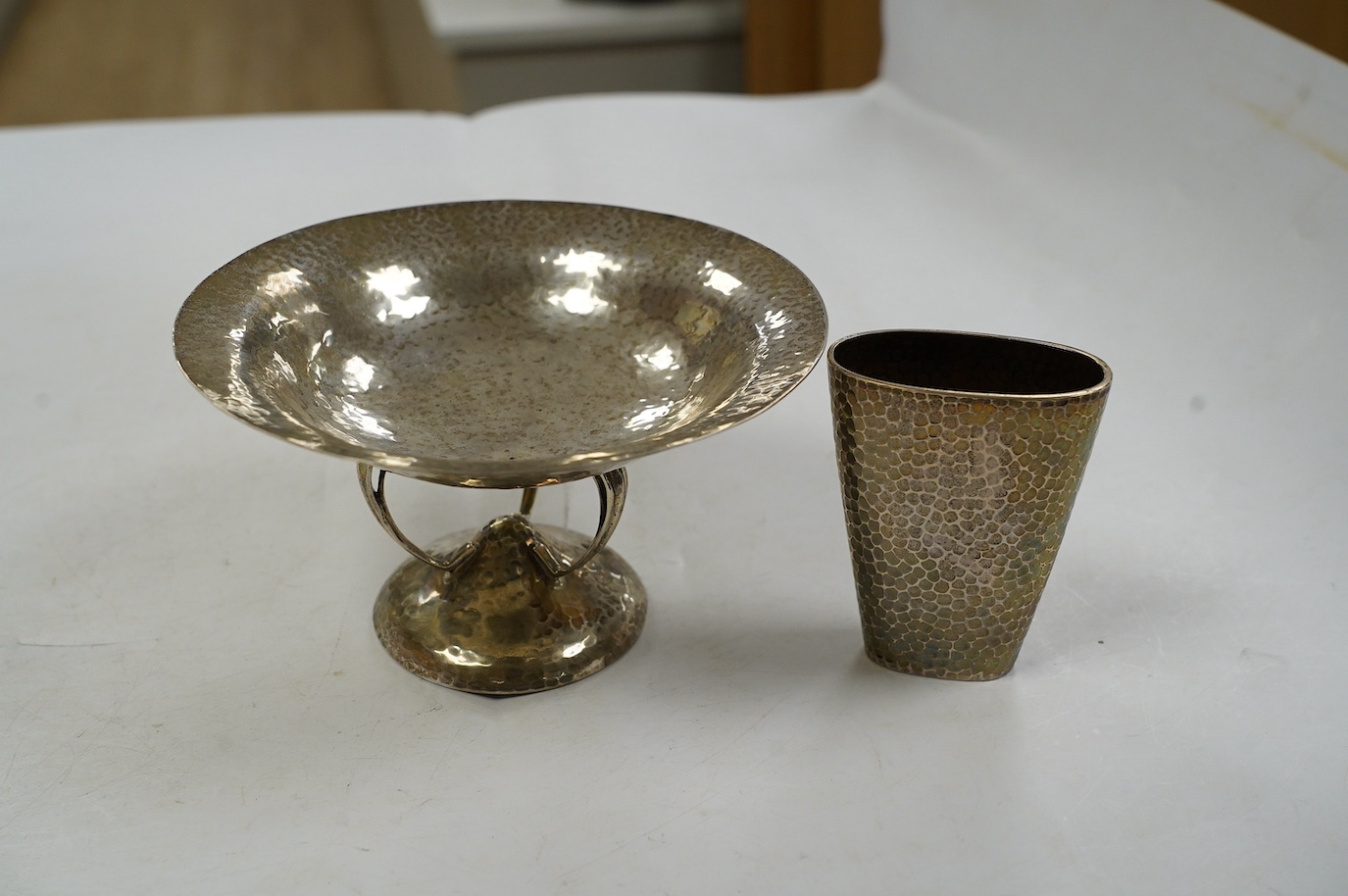 A George V Arts & Crafts planished silver bowl, on tripod supports and circular foot, Walker & Hall, Sheffield, 1912, diameter 15.7cm and a German planished vase inscribed 'Weihnachten 1897'. Condition - fair